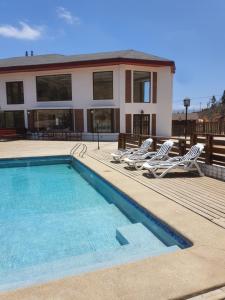 uma casa com uma piscina e duas espreguiçadeiras em Casa Tabolango , Limache em Limache