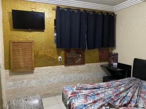 um quarto com uma cama e uma televisão na parede em HOTEL MEDIEVAL em São Paulo