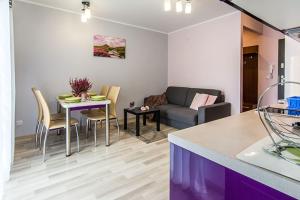 ein Wohnzimmer mit einem Sofa und einem Tisch in der Unterkunft Apartament Wrzosowy - 5D Apartamenty in Świeradów-Zdrój