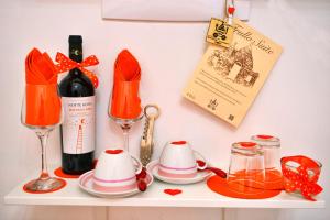 a shelf with a bottle of wine and two wine glasses at Trullo Suite in Cisternino