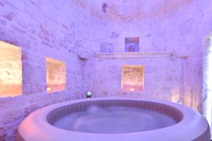 un ampio bagno con una grande vasca in una stanza di Trullo Suite a Cisternino Altre 37 foto