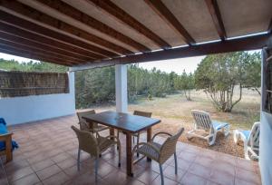 un patio con tavolo e sedie in legno di CASA GORKA Cala Saona a Cala Saona