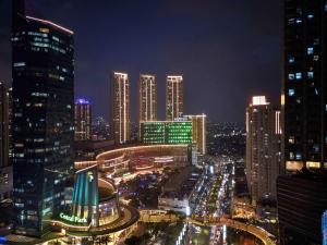 een stad verlicht in de nacht met hoge gebouwen bij Pullman Jakarta Central Park in Jakarta