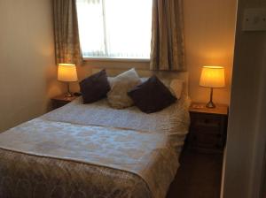 a bedroom with a bed with two lamps and a window at White Lodge Guest House in Skegness