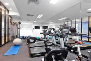 a gym with rows of treadms and cardio machines at Pegasus Apart-Hotel in Melbourne