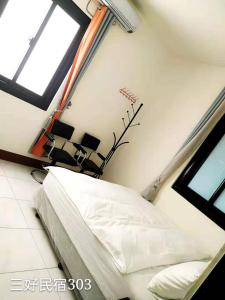 a bedroom with a bed and a window at Sun Good Hostel in Hengchun