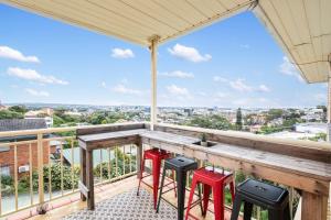 a balcony with a wooden bar with stools at Beach Haven on The Hill in Newcastle