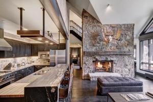 a kitchen and living room with a stone fireplace at Stunning 4 bedroom condo Snowcloud base of Bachelor Gulch condo in Avon