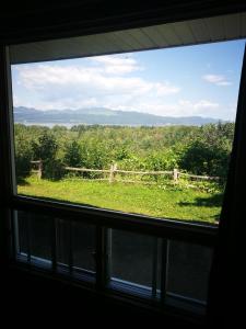 a view of a field from a window at Auberge La Coudriere (Cool Hotel) in L'Isle-aux-Coudres