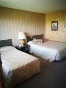 une chambre d'hôtel avec deux lits et une lampe dans l'établissement Auberge La Coudriere (Cool Hotel), à L'Isle-aux-Coudres