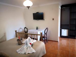 Habitación con mesa y TV en la pared. en Hotel Español en San Fernando