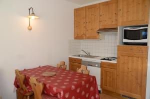 een kleine keuken met een tafel en een magnetron bij Appartement Flaine Forêt in Flaine