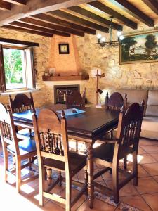 een eetkamer met een tafel en stoelen en een open haard bij The Cliffs - Casa Crecide in O Vicedo
