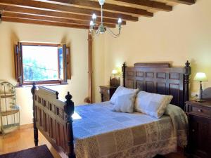 een slaapkamer met een bed met een blauw dekbed en een raam bij The Cliffs - Casa Crecide in O Vicedo