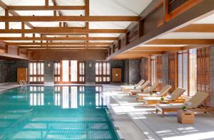 a hotel pool with lounge chairs and a swimming pool at Jinmao Hotel Lijiang, the Unbound Collection by Hyatt in Lijiang