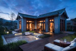 a house with a deck and a patio at Jinmao Hotel Lijiang, the Unbound Collection by Hyatt in Lijiang