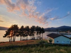 a house on the shore of a body of water at Teo's Guest House in Dospat