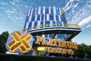 a tall building with a sign in front of it at Platinum Adisucipto Hotel & Conference Center in Yogyakarta