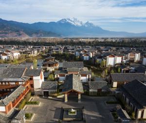 an aerial view of a town with a mountain in the background at Jinmao Hotel Lijiang, the Unbound Collection by Hyatt in Lijiang