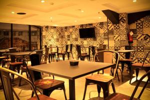 a restaurant with tables and chairs in a room at SOTIS Hotel Kemang, Jakarta in Jakarta