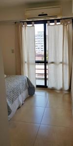 a bedroom with a bed and a large window at L&B Departamento Excelente Ubicación in San Miguel de Tucumán