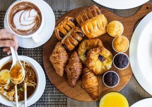 a table with a plate of pastries and a cup of coffee at Holiday Inn Singapore Atrium, an IHG Hotel in Singapore