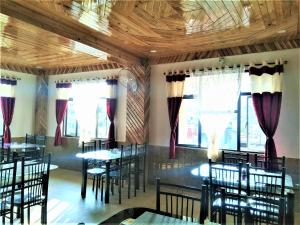 Sulawado Resort في تشيرابونجي: غرفة طعام مع طاولات وكراسي ونوافذ