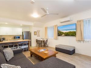 a living room with a couch and a table at Blueys Motel in Blueys Beach