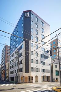 a tall building on a city street with a street at MONday Apart Premium Ginza Shintomicho in Tokyo +102 photos