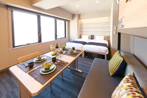um quarto com duas camas e uma mesa com comida em MONday Apart Premium 銀座新富町 em Tóquio