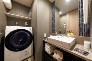 a bathroom with a washing machine and a sink at MONday Apart Premium 銀座新富町 in Tokyo