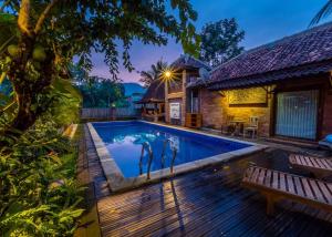 a villa with a swimming pool and a house at The Amrta Borobudur in Borobudur