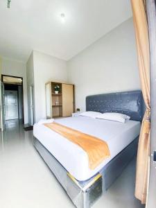 ein Schlafzimmer mit einem großen weißen Bett in einem Zimmer in der Unterkunft Darma Palace Syariah in Padang