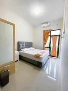 a bedroom with a large bed and a window at Darma Palace Syariah in Padang