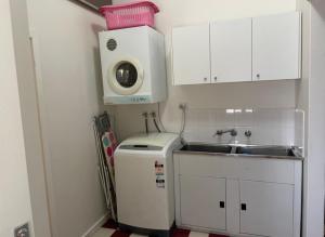 eine kleine Küche mit einer Spüle und einer Mikrowelle in der Unterkunft Yea River Cottage in Yea