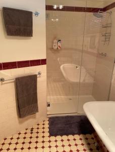 uma casa de banho com um chuveiro, uma banheira e um lavatório. em Yea River Cottage em Yea