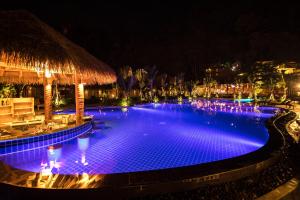 a large swimming pool at night with purple lights at Phi Phi CoCo Beach Resort in Phi Phi Islands