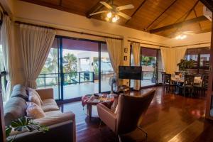 a living room with a couch and a tv at Baan SanSuk Pranburi - Beach Front & Pool Villa in Pran Buri