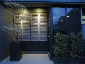 einer Haustür eines Gebäudes mit Topfpflanze in der Unterkunft Haus Inn in Taitung