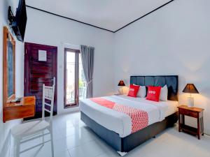 a bedroom with a large bed with red pillows at Bahtera Guest House in Denpasar