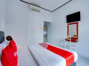 a bedroom with a large bed with a red blanket at Bahtera Guest House in Denpasar +17 photos