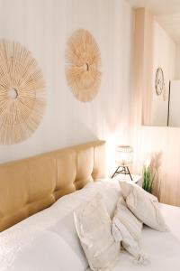 een slaapkamer met een bed met witte lakens en 2 spiegels bij Apartment an der Altstadt (#7) in Hameln