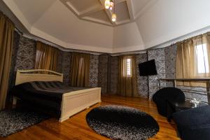 a bedroom with a bed and a couch and a tv at Krepost Mini Hotel in Makhachkala