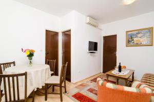a living room with a table and chairs and a television at Apartment Amela in Dubrovnik