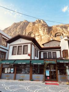a building on a street with a mountain in the background at Ziyagil Konağı in Amasya