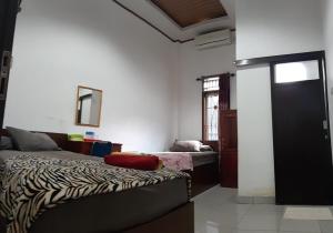 Ένα ή περισσότερα κρεβάτια σε δωμάτιο στο Losmen Ibu Hj. Tarjo