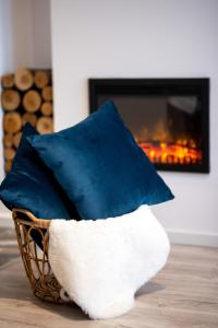 - un panier d'oreillers installé devant une cheminée dans l'établissement Snowdrop Apartment, à Sinaia
