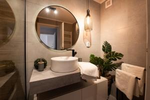 une salle de bains avec un lavabo et un miroir dans l'établissement Snowdrop Apartment, à Sinaia 23 autres photos