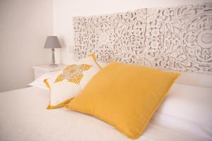 a bed with two pillows and a yellow blanket at Il Gelsomino in Roseto degli Abruzzi