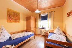 1 dormitorio con 2 camas y ventana en Ferienwohnung Hartwimmer - Chiemgau Karte, en Inzell